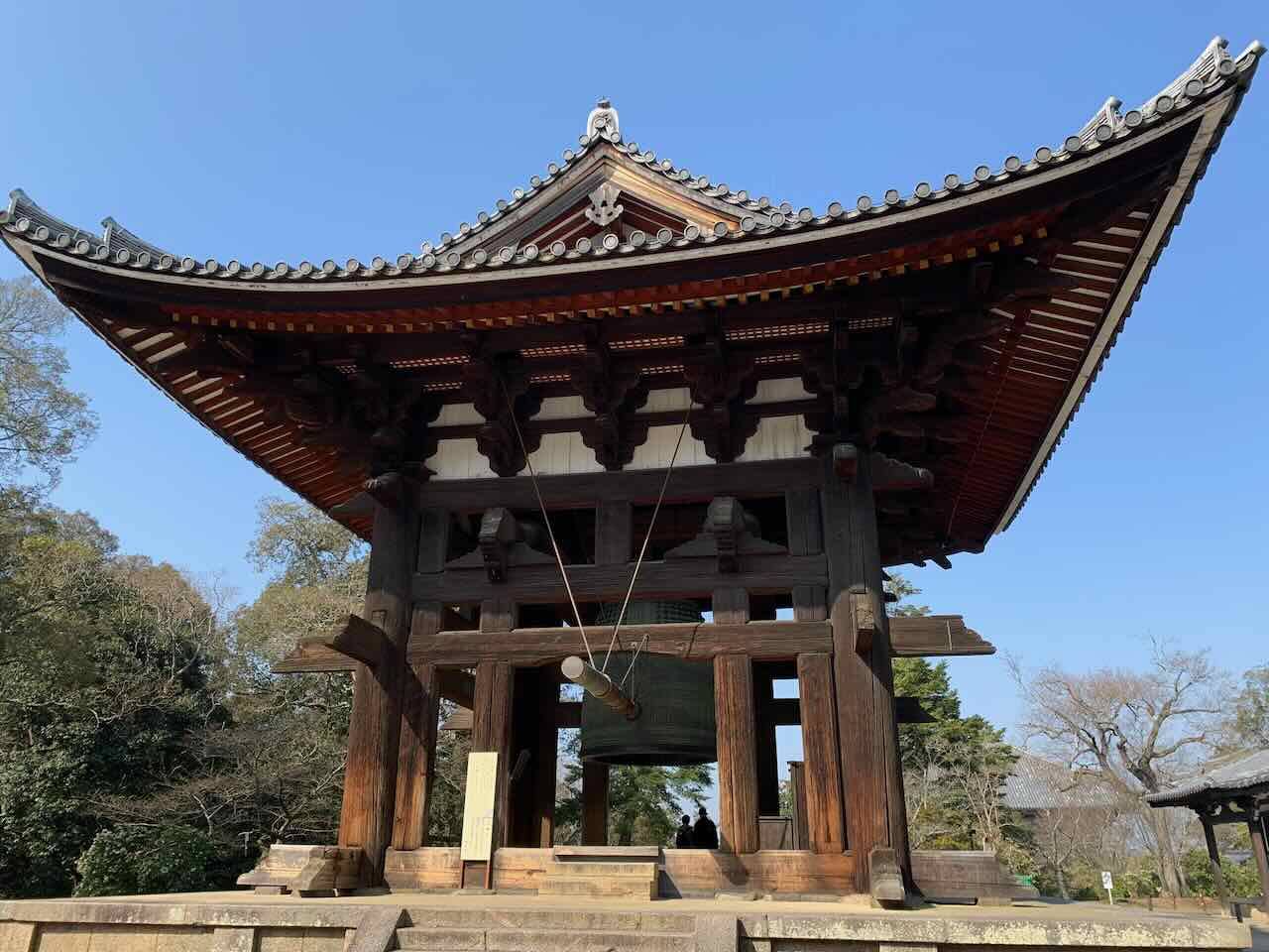 Große buddhistische Tempelglocke in einem hölzernen Glockenturm mit waagerecht aufgehängtem Shumoku